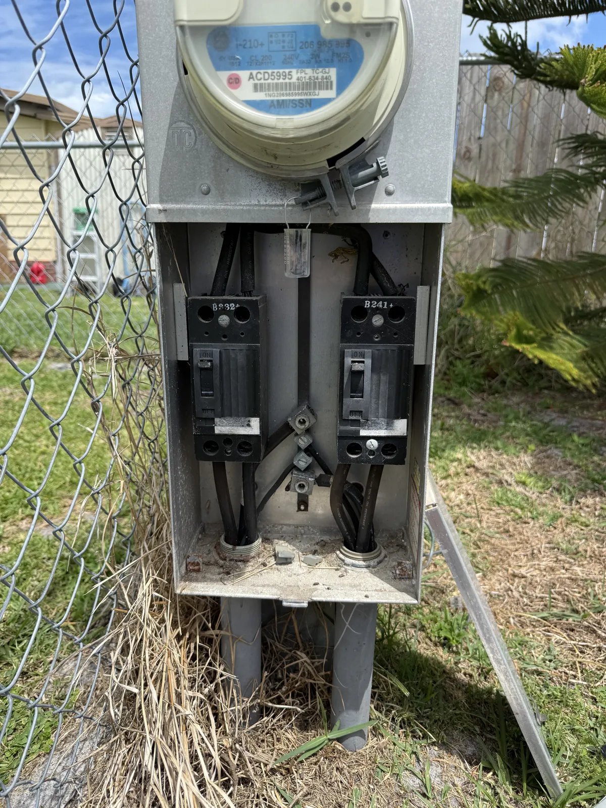 Open meter pedestal in Barefoot Bay showing corrosion at the base pan and weathered breakers